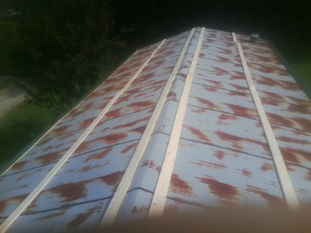 Rusted metal roof panels with new wood purlins before replacement — Storm Damage Roof Repair in Kenneth by Roofing Brothers