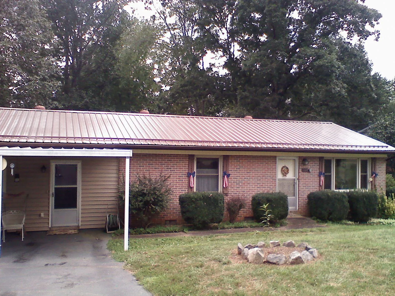 Bronze metal roof and carport on a brick ranch home — Roof Repair work by our crew in Kenneth